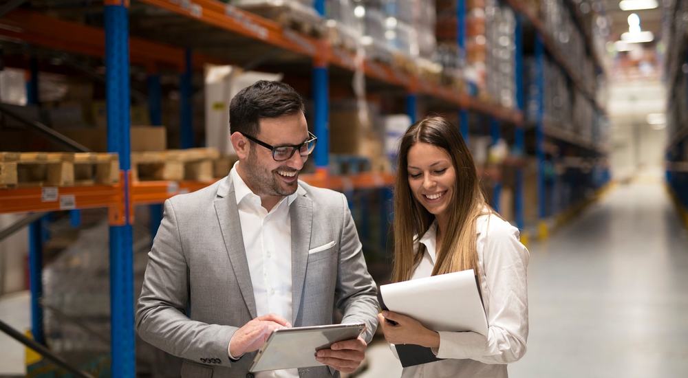 A warehouse manager and consultant review operational data together, reflecting the collaborative analysis needed before selecting a Warehouse Management System.