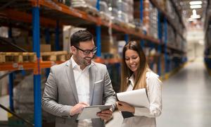 A warehouse manager and consultant review operational data together, reflecting the collaborative analysis needed before selecting a Warehouse Management System.