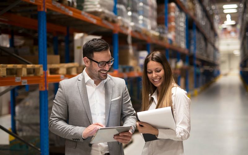 A warehouse manager and consultant review operational data together, reflecting the collaborative analysis needed before selecting a Warehouse Management System.